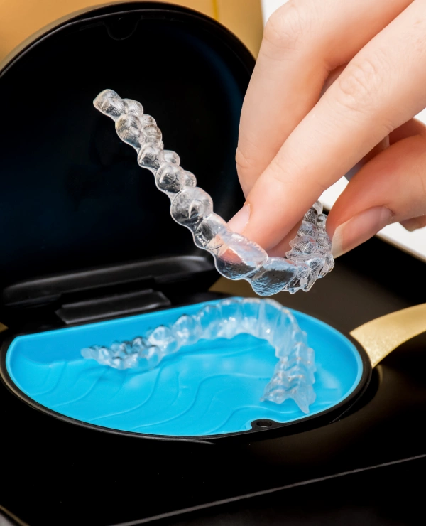 Dentist holding a clear Invisalign aligner